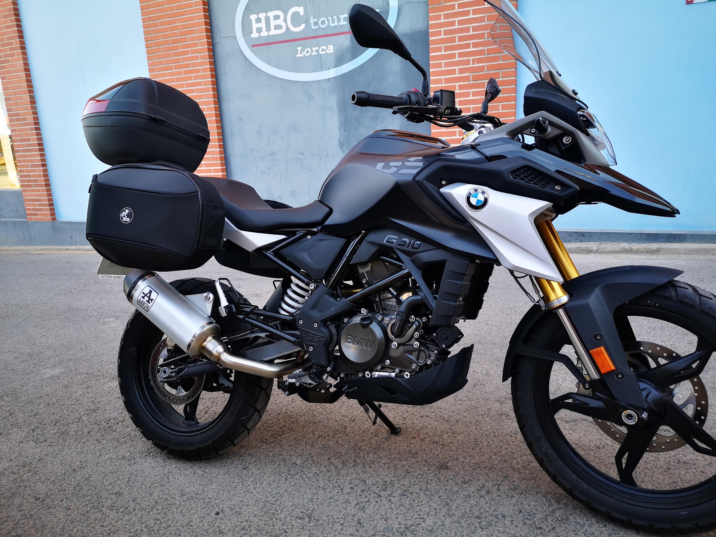 BMW G 310 GS frente al rótulo de HBC Touring